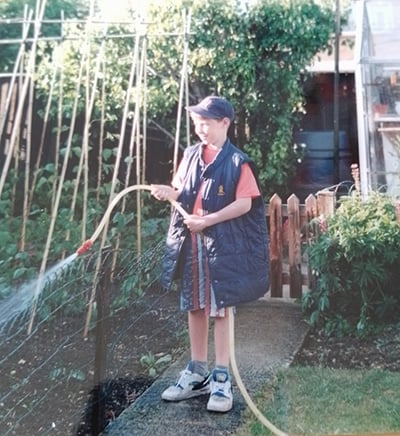 Tom Knight as a boy watering garden plants