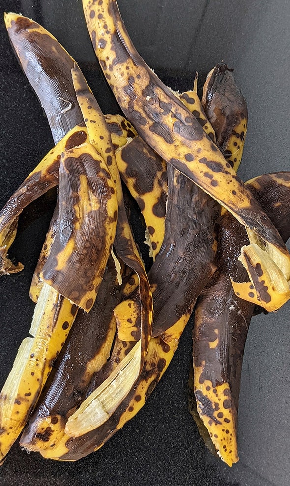 Peeled Banana skins on a dark granite kitchen worktop