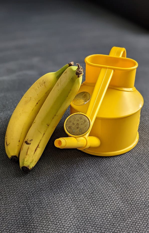 Yellow watering can next to yellow bananas