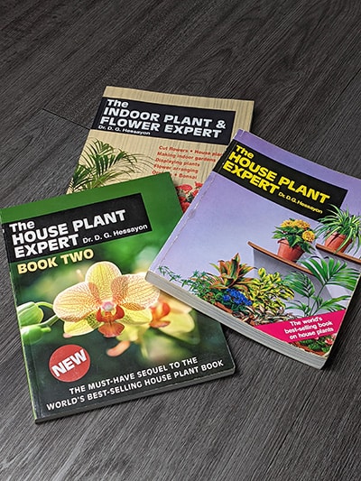 Three indoor plant expert books by Dr D. G. Hessayon laid out on a floor
